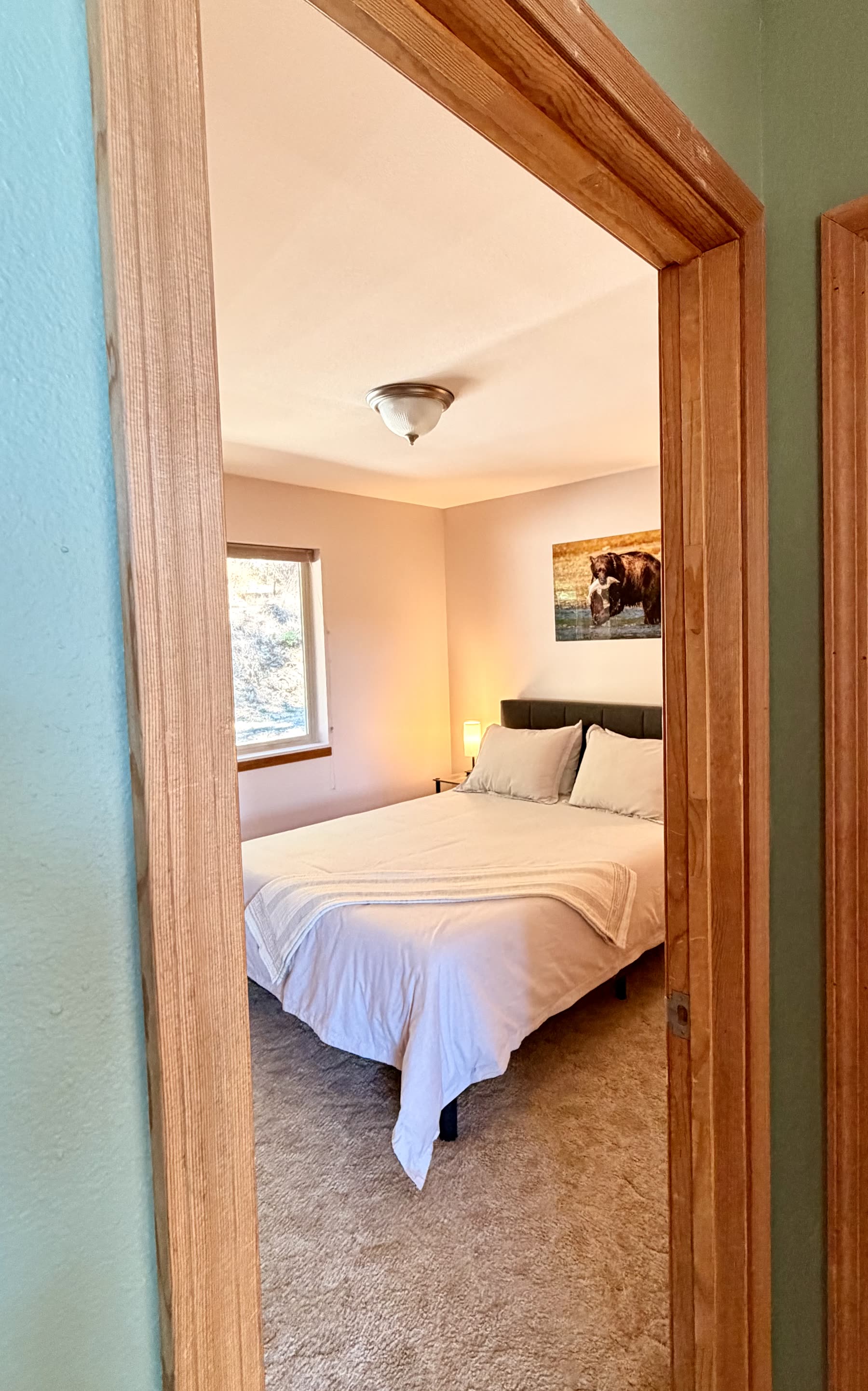 Second bedroom with queen bed and soft evening light