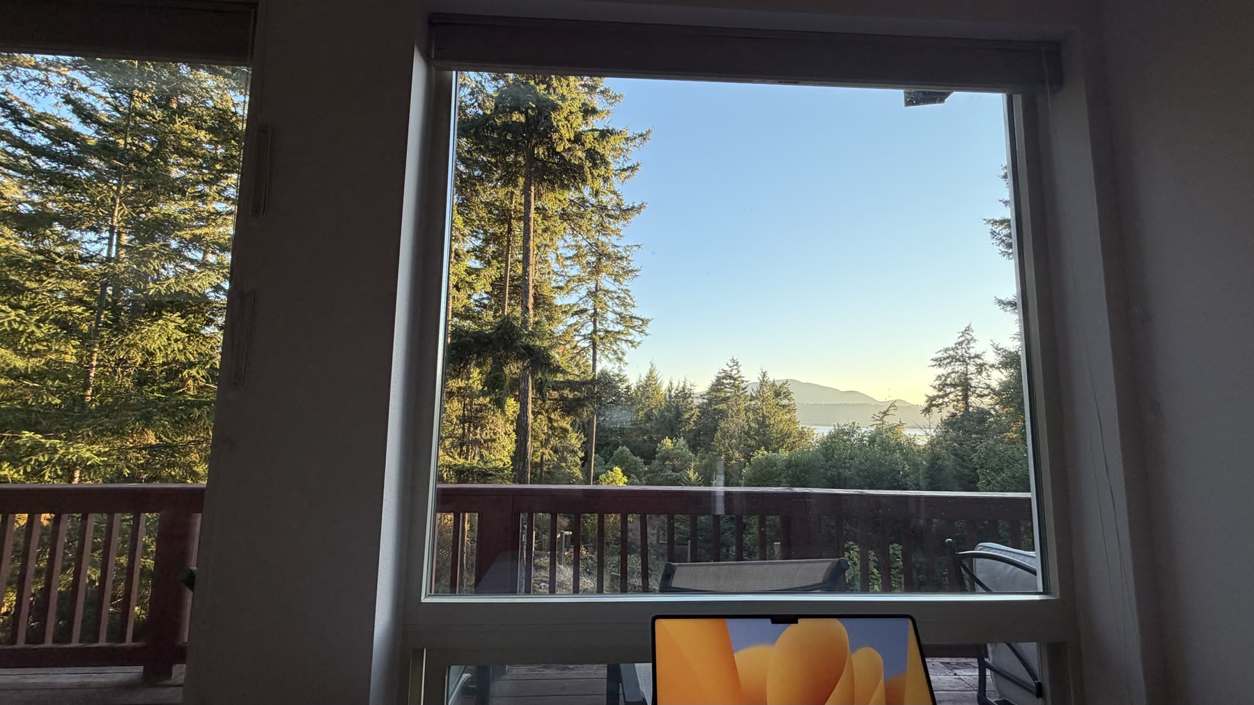 Picture window framing the deck and the water beyond