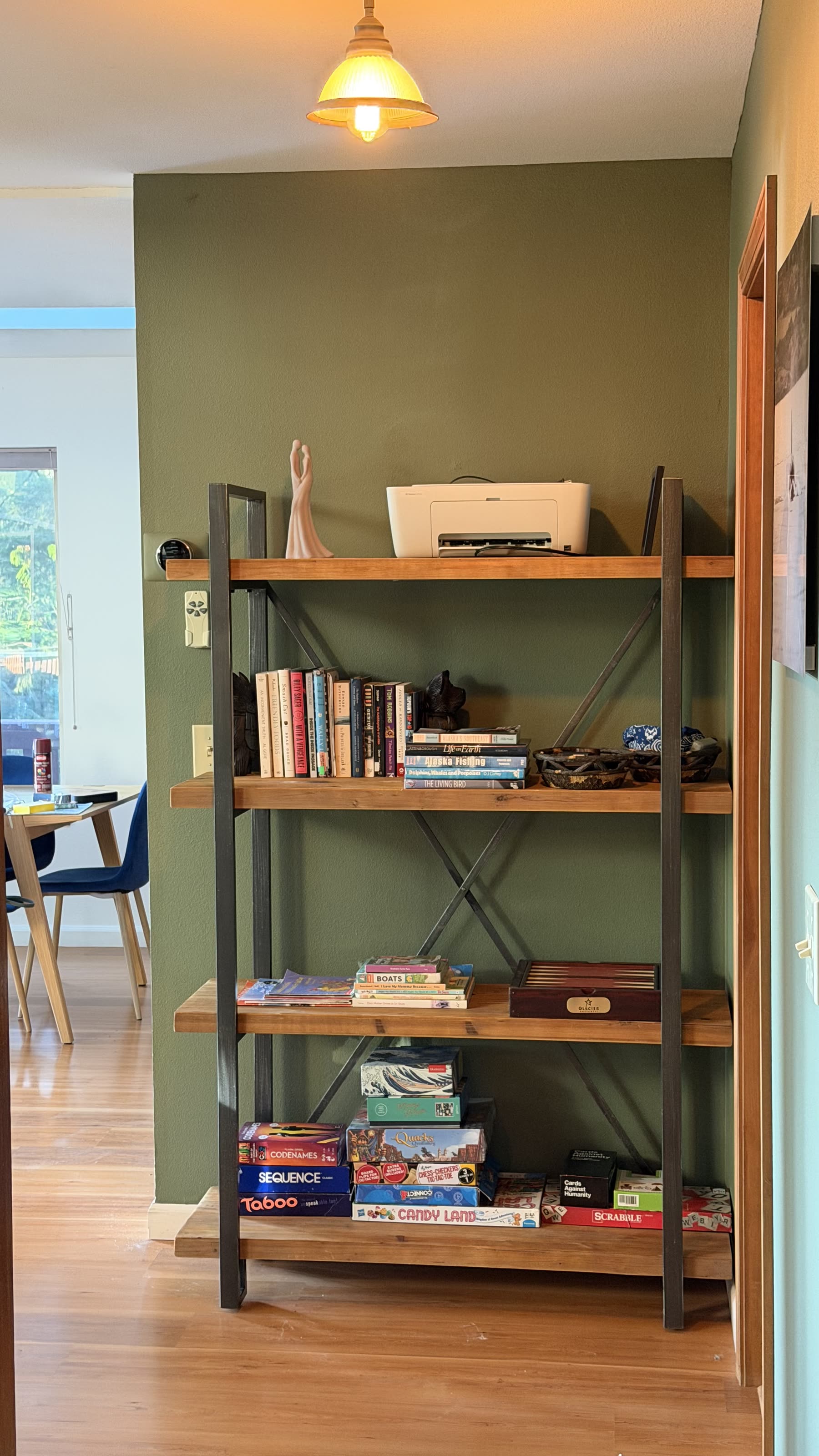 Shelf of books, puzzles and board games for guests