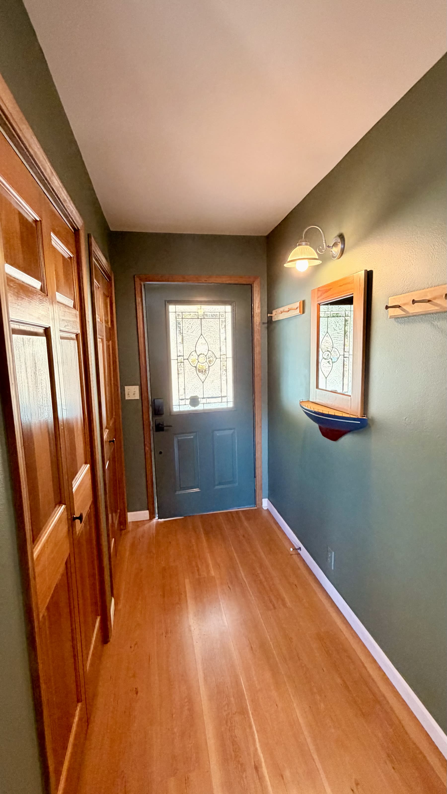 Entry hall with stained-glass front door and wood floors
